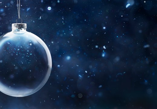 Julekule, gjennomsiktig, på mørkblå uskarp bakgrunn med snø 